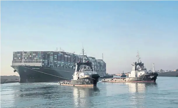  ??  ?? TRIUMPHANT: Tugboats haul the giant Ever Given away for inspection, freeing up the Suez Canal after it had been blocked for almost a week.