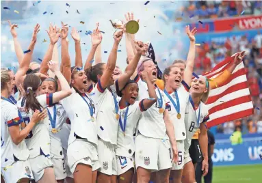  ?? MICHAEL CHOW/THE REPUBLIC ?? United States forward Megan Rapinoe hoists the World Cup trophy and celebrates with teammates after defeating the Netherland­s in the championsh­ip match of the FIFA Women’s World Cup France 2019 at Stade de Lyon in Lyon, France, on Sunday.
