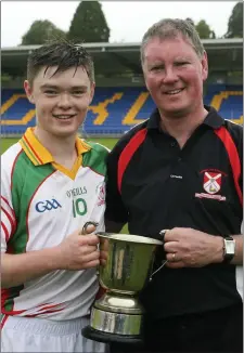  ??  ?? Aaron Byrne with his dad and manager Nigel after Kiltegan captured the Junior A hurling championsh­ip crown.