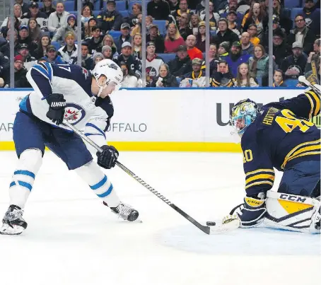  ?? KEVIN HOFFMAN/GETTY IMAGES ?? Sometimes goalies get lucky, as was the case here for Sabre Carter Hutton against the Jets’ Adam Lowry last Sunday.