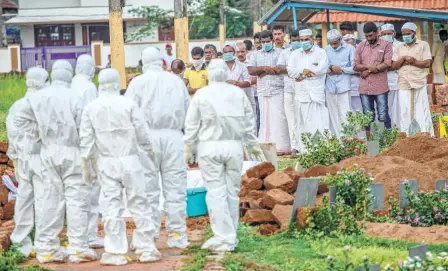  ??  ?? RELATIVES and hospital staff wearing safety gear at the funeral of V. Moosa, a victim of the Nipah virus infection, in Kozhikode on May 24.