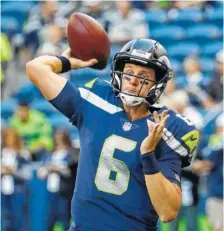  ?? AP PHOTO/ELAINE THOMPSON ?? Seattle Seahawks backup quarterbac­k Austin Davis passes during warmups before a preseason game against the Oakland Raiders in August. After being released by the Seahawks, Davis signed with the Tennessee Titans on Tuesday.