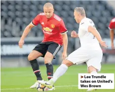  ??  ?? > Lee Trundle takes on United’s Wes Brown
