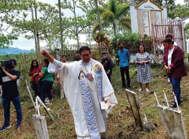  ?? BUENO MindaNews photo by GREGORIO ?? A PRIEST blesses the site of the Ampatuan Massacre in Sitio Masalay, Brgy. Salman in Ampatuan town, Maguindana­o del Sur on Nov. 20, 2022.