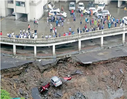  ?? AP ?? Cars lie buried in debris after the wall of an under-constructi­on building collapsed during heavy rains in Mumbai on Monday.—
