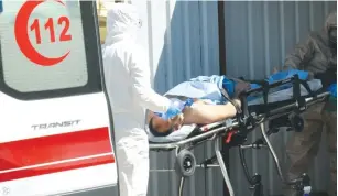  ?? (Reuters) ?? A SYRIAN FROM Idlib is carried by Turkish medics wearing chemical protective suits to a hospital in the border town of Reyhanli in Turkey’s Hatay province.