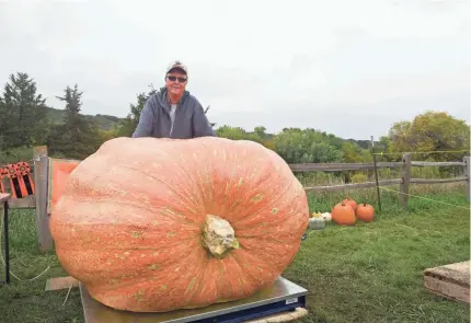  ?? ?? Greg Kurkowski, of Watertown, S.D., poses with his record-setting 1,823-pound pumpkin at the Great South Dakota Pumpkin Weigh-Off. The Atlantic Giant is the largest pumpkin grown in South Dakota state history, breaking the previous record of 1,674 pounds set by Kevin Marsh in 2010.