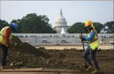  ?? J. Scott Applewhite/Associated Press ?? Workers repair a park Wednesday near the Capitol in Washington. Senators working on the infrastruc­ture plan hope to have a bill ready to be voted on next week.