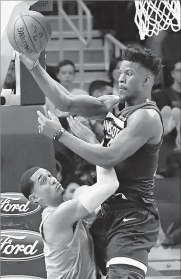  ?? Jim Mone Associated Press ?? MINNESOTA’S Jimmy Butler passes around the Lakers’ Jordan Clarkson in their game in Minneapoli­s. Butler led all scorers with 28 points while Clarkson scored 20 as the Lakers lost their seventh in a row.