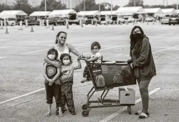  ?? Scott Dalton / Washington Post ?? Adriana Contreras and her four children — Delilah, 17; Diana, 8; Dominic, 5; and Damian, 3 — got food at the pedestrian section of a distributi­on center at NRG Stadium in Houston.