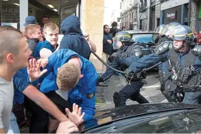  ??  ?? Get back! Officers wield their riot sticks to contain England supporters