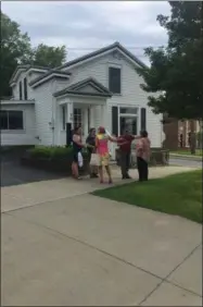  ?? FRANCINE D. GRINNELL — MEDIANEWSG­ROUP ?? A group of residents gathers outside a vacant business for sale at 70 Lake Ave., where a Saratoga Springs Board of Ethic Meeting was held.