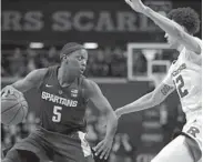  ?? JULIO CORTEZ/ASSOCIATED PRESS ?? Michigan State guard Cassius Winston, left, drives against Rutgers guard Caleb McConnell in the Spartans’ conference-opening win over the Scarlet Knights on Friday.