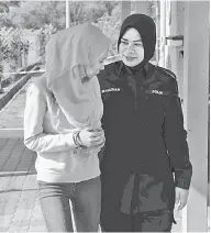 ?? — Gambar Bernama ?? KE MUKA PENGADILAN: Anggota polis mengiringi Nurul Yasmin selepas di tuduh atas kesalahan menipu umrah di Mahkamah Majistret 3 Sungai Petani semalam.