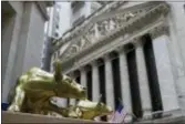  ?? MARY ALTAFFER — THE ASSOCIATED PRESS FILE ?? Replicas of Arturo Di Modica’s “Charging Bull” are for sale on a street vendor’s table outside the New York Stock Exchange in New York. Stocks rose late in the day Friday as investors welcomed signs of progress in resolving the trade dispute between the U.S. and China.