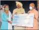  ?? DEEPAK GUPTA/HT ?? CM Yogi Adityanath giving a cheque to a beneficiar­y on the occasion of Vishwkarma Jayanti that coincided with PM’s birthday.