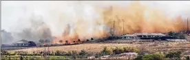  ?? MATTHEW THAYER / THE MAUI NEWS ?? Windswept flames and smoke rush toward a pair of luxury homes Friday in Launiupoko, Hawaii. By late Friday, Lane had maximum sustained winds of 70 mph as it slowly twisted west about 120 miles south of Honolulu.