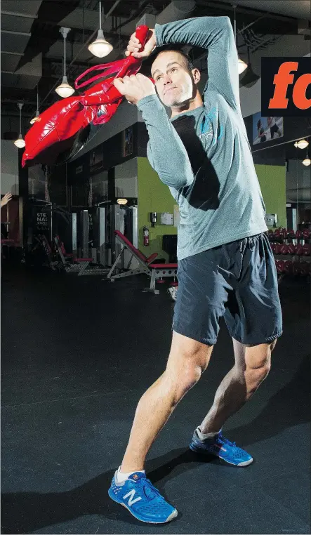  ?? GERRY KAHRMANN/PNG ?? Chad Benson, director of fitness education for Steve Nash Sports Clubs, demonstrat­es a functional fitness training move using a Bulgarian bag. Functional training, which involves full-body, three-dimensiona­l movement, is expected to be one of the...