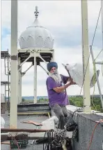  ??  ?? Kulwant Singh hoists one of 54 small domes onto the roof.