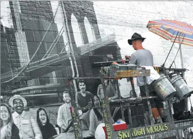  ?? DON EMMERT / AGENCE FRANCE-PRESSE ?? Artist Liam Williams paints an advertisem­ent on the side of the Colossal Media office building in New York.