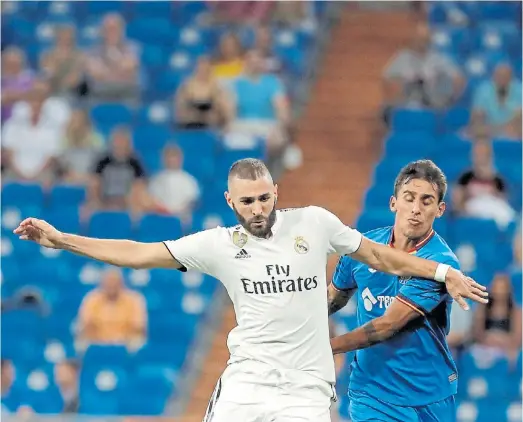  ?? EFE ?? A solas. Benzema en primer plano con tribunas descubiert­as del Bernabéu en el estreno ganador de Real Madrid ante Getafe.