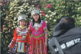  ?? QU HONGLUN / CHINA NEWS SERVICE ?? A tourist and her daughter dressed in traditiona­l clothes pose for a photo in the Baili Azalea Administra­tive Zone in Bijie, Guizhou province.