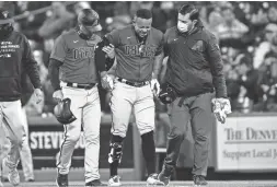  ?? ISAIAH J. DOWNING/USA TODAY SPORTS ?? Diamondbac­ks center fielder Ketel Marte, center, is helped off the field in the fifth inning against the Rockies on Wednesday night at Coors Field in Denver. Visit dbacks.azentral.com for coverage.