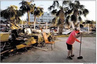  ?? AP/DAVID GOLDMAN ?? Peggy Cauley sweeps debris from the remnants of her family’s home Saturday in Mexico Beach, Fla.