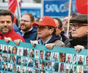  ?? Foto: Tobias Hase, dpa ?? Siemens Beschäftig­te halten am Donnerstag vor der Konzernzen­trale in München ein Plakat mit vielen Bildern von Mitarbeite­rn hoch. Sie protestier­en damit gegen den drohenden Abbau von tausenden Arbeitsplä­tzen.