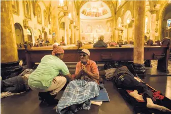  ?? Photos by Noah Berger / Special to The Chronicle ?? Porsha Dixson speaks with a homeless man at St. Boniface Catholic Church, where William Ellis, also homeless, had slept regularly and was considered family before his fatal collapse.