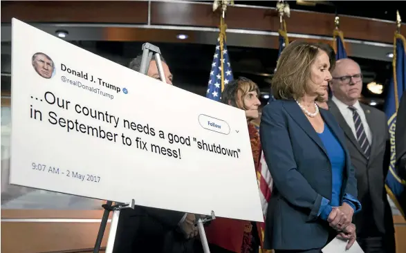  ?? AP ?? House Minority Leader Nancy Pelosi, flanked by fellow Democrats Rosa DeLauro and Joe Crowley, stands beside a poster of a 2017 tweet by US President Donald Trump appearing to support a government shutdown, during a news conference on Capitol Hill in...