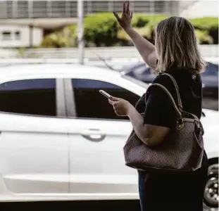  ?? Avener Prado/folhapress ?? Passageira espera carro de aplicativo; modalidade entra pela primeira vez na pesquisa Origem Destino, do Metrô e já são 362 viagens ao dia na Grande SP