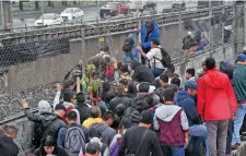  ??  ?? Para salir de la zona inundada en la calzada Ignacio Zaragoza, las personas optaron por caminar sobre las vías del Metro que no estaba operando.