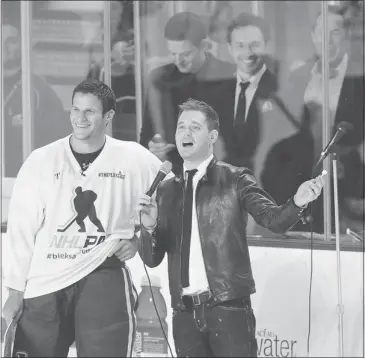  ?? Mark van Manen/postmedia News ?? Michael Bublé joins Vancouver Canucks player and pal Kevin Bieksa on home ice during the Bieksa’s Buddie Charity hockey game in October. The crooner says he’d never consider not coming home for the holiday season in Vancouver.