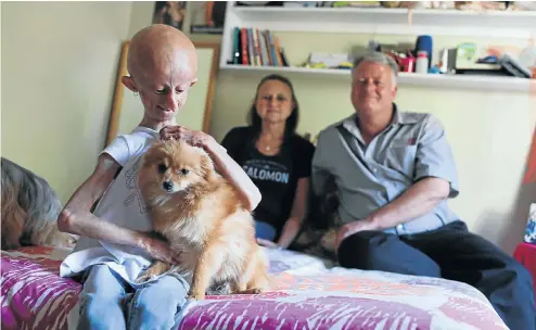  ?? Picture: Alaister Russell ?? Beandri Booysen, 13, with her dog Tinky. With her are her parents Bea and Pieter Booysen at their home in Pretoria.