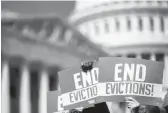  ?? STEFANI REYNOLDS/THE NEW YORK TIMES ?? Activists hold “end evictions” signs Sept. 21 on Capitol Hill in Washington.