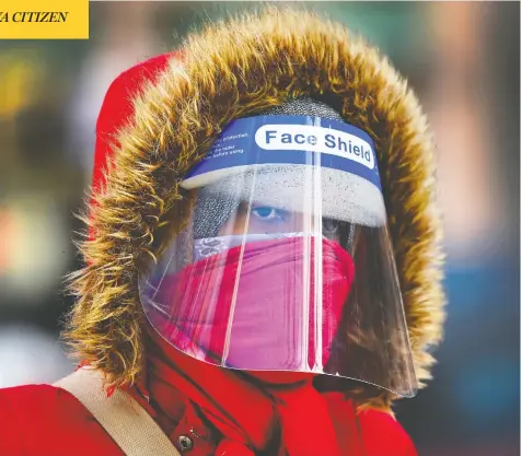  ?? NATHAN DENETTE / THE CANADIAN PRESS ?? A woman adds a PPE visor to the layers of clothing keeping out the cold during a chilly February day in Toronto on Thursday.