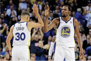  ?? [AP PHOTO] ?? Kevin Durant and Steph Curry celebrate a score against Philadelph­ia on Nov. 11.