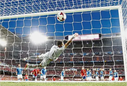  ?? — AP / Reuters ?? That’s a handful: Italy goalkeeper Gianluigi Buffon fails to stop a shot from Spain’s Isco in the 2018 World Cup qualifier at the Bernabeu in Madrid on Saturday. Below: Isco is hugged by Sergio Ramos after scoring.