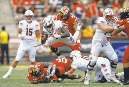  ?? PATRICK SEMANSKY/AP PHOTOS ?? Temple’s Ryquell Armstead, center, leaps over Maryland defensive lineman Oseh Saine (93) and defensive back Antwaine Richardson on Saturday.