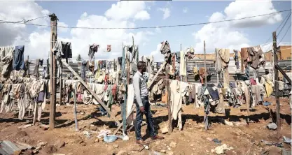  ?? | ?? TESTIMONY A MAN looks at the clothes of those who were killed in Rwanda’s 1994 genocide, hung at one of the excavation sites in the suburbs of the capital, Kigali, at the weekend. Rwanda yesterday marked the 25th anniversar­y of the genocide when Hutu extremists killed Tutsis and moderate Hutus during a three-month killing spree that resulted in, according to Rwanda, the death of more than one million people. Rwandan President Paul Kagame laid a wreath at the Gisozi genocide memorial site, where over a quarter a million of people are buried, kicking off a week of solemn ceremonies around the country.