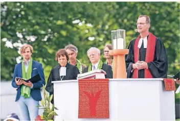  ??  ?? Kirchentag­spastor Arnd Schomerus auf der Bühne des Eröffnungs­gottesdien­stes. Hinter ihm stehen Annette Kurschus und Hans Leyendecke­r.