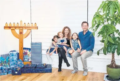  ?? COLE BURSTON TORONTO STAR ?? Julia and Larry Borins with daughters Hana, 5, Ruby, 2, and Lyla, 8, with the family menorah in their refurbishe­d home.