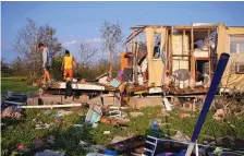  ?? JOHN LOCHER/ASSOCIATED PRESS ?? Aiden Locobon, left, and Rogelio Paredes look through the remnants of their family’s home, which was destroyed by Hurricane Ida in Dulac, La.