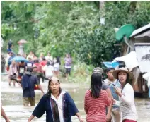  ??  ?? Villagers wade through a flooded street in Brgy Calingatng­an, Philippine, on Saturday. (AFP)