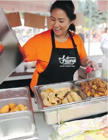  ?? LEAH HENNEL ?? Katrina Panis prepares food at La Fritanga for Fiestaval, which runs through Sunday at Olympic Plaza.