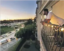  ?? Don Bartletti Los Angeles Times ?? EVERETT SMITH, a renter at the Orsini apartments, looks out from his balcony at rush hour traffic on the 101 and 110 freeway interchang­e in L.A.