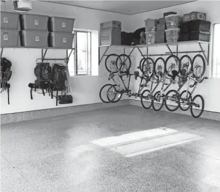  ?? MONKEY BAR STORAGE ?? An epoxy coating can dress up the plain concrete floor in a garage, and shelving and bike racks help create space in the interior and along the walls.