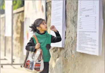  ?? RAVI CHOUDHARY/HT PHOTO ?? A child looks at the notice board put up outside a school in Karol Bagh on Monday. Many parents checked the websites for informatio­n and the form but visited schools just to be sure about the process.