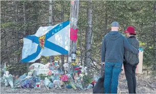  ?? ANDREW VAUGHAN THE CANADIAN PRESS FILE PHOTO ?? A couple pays their respects at a roadblock in Portapique, N.S., last month. A court document offers disturbing witness descriptio­ns of the state of mind of shooter Gabriel Wortman.